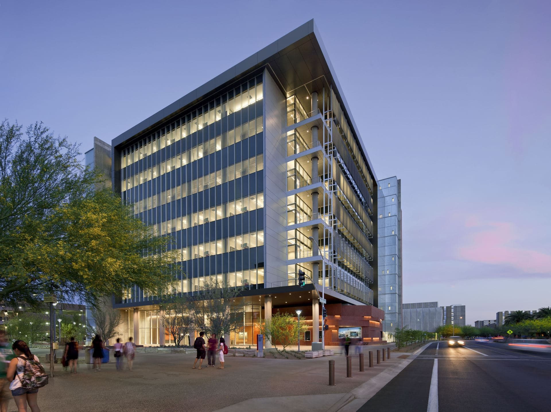 The Arizona State University School of Earth and Space Exploration building at dusk, with students walking in front