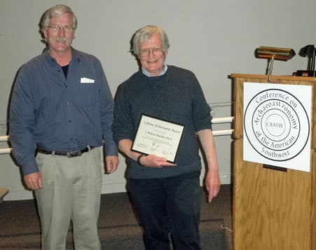 Dr. J. McKim Malville holds his framed Lifetime Achievement Award certificate beside Dr. Todd Bostwick