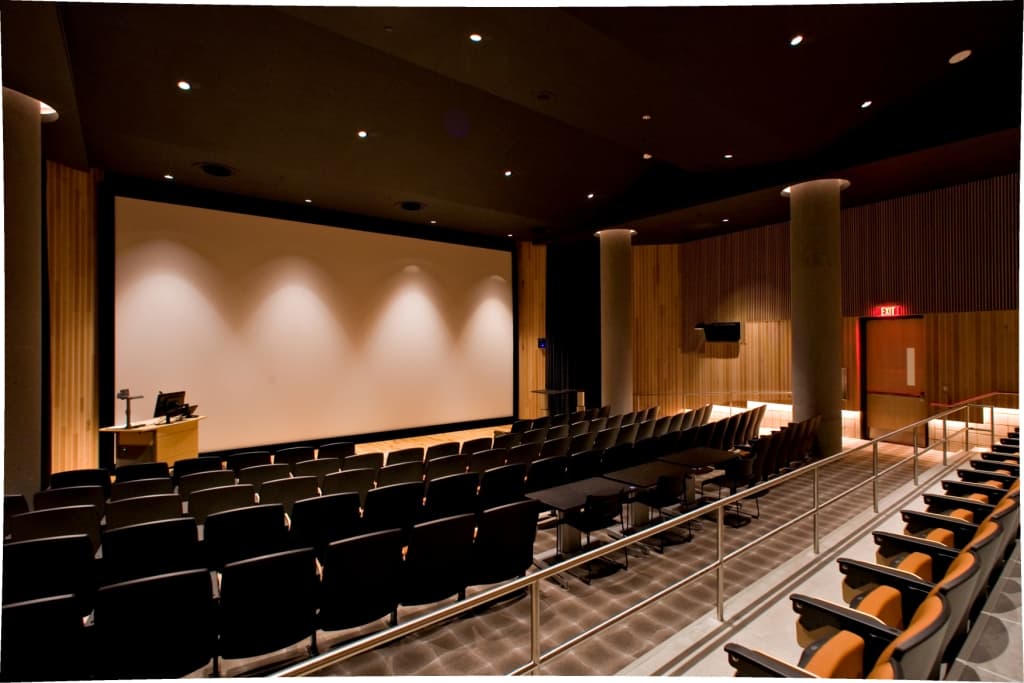 Inside the Marston Exploration Theater: tiered seating, a large projection screen and a lectern