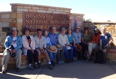 Field-trip group seated in front of the Hovenweep National Monument Visitor Center stone sign