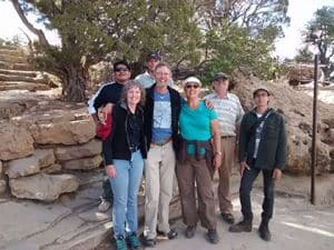 Field-trip participants posing on a stone path among juniper trees at Mesa Verde