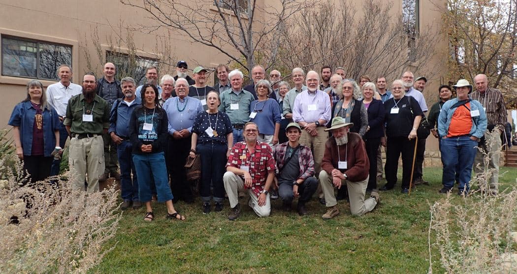 About 40 attendees of the 2016 conference, wearing name badges, gathered on a lawn outside Crow Canyon Archaeological Center