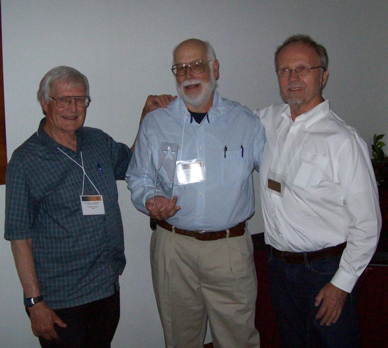 GB Cornucopia holds a glass star award, standing between Kim Malville and Tony Hull